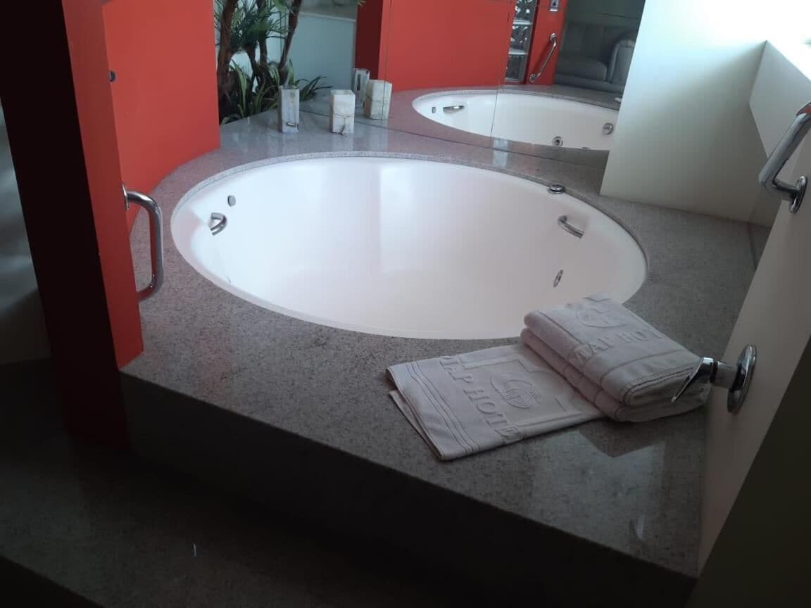 A bathroom with a round sink, a towel, and a mirror.