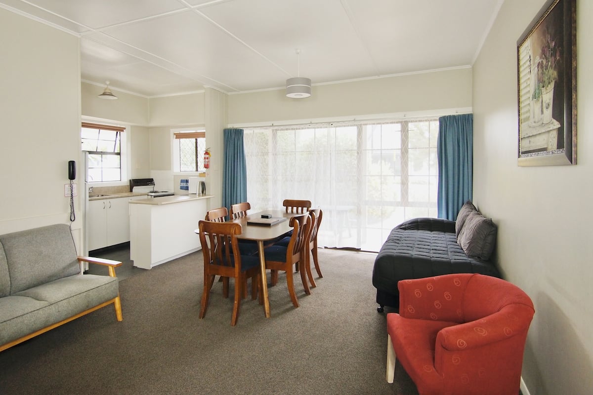 A compact living space with a dining area, kitchenette, and seating arrangements.