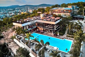 A modern hotel with a rooftop pool, outdoor seating, and a view of the city. - Son Tra Hill Phu Quoc (Phu Quoc)