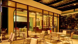 Un espace intérieur aménagé avec des tables et des chaises, de grandes fenêtres et une vue sur l’espace intérieur.