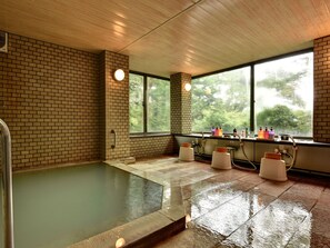 A spa room with a wooden ceiling, brick walls, a large window, and a bathtub. - Hakone Gora Onsen Mizu no Kaori - Hostel (Hakone)