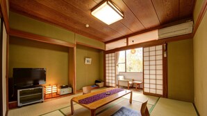 A traditional Japanese room with tatami flooring, a low wooden table, a television, and sliding doors. - Hakone Gora Onsen Mizu no Kaori - Hostel (Hakone)