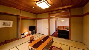 A traditional Japanese room with tatami flooring, a low wooden table, a television, sliding doors, and a futon bed. - Hakone Gora Onsen Mizu no Kaori - Hostel (Hakone)