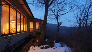 A modern house with large windows, a brick exterior, and a snowy landscape in the background. - Hakone Gora Onsen Mizu no Kaori - Hostel (Hakone)