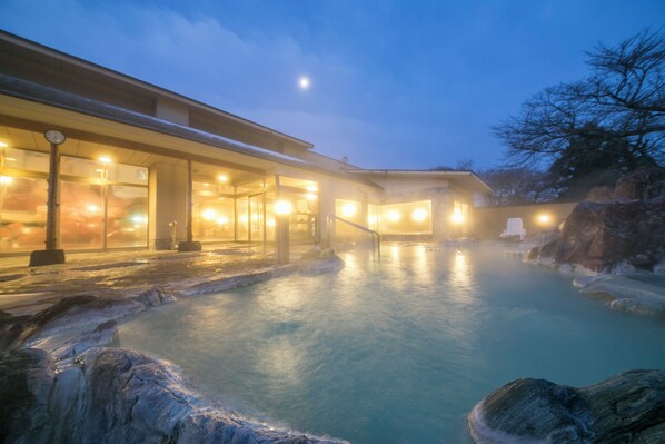 A spa with a heated pool, a clock, and a chair outside. - Kintarouonsen (Uozu)