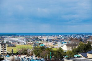 A residential area with houses, a parking lot, and a view of the sea. - Kintarouonsen (Uozu)
