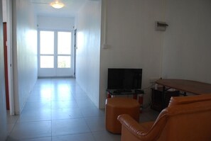 A living room with a TV, a sofa, and a coffee table. - La Dorade (Trou aux Biches)