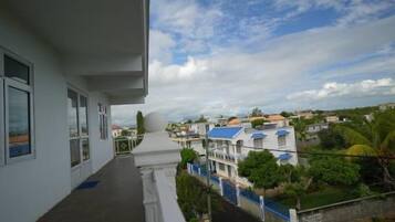 A residential balcony with a view of neighboring houses and greenery.