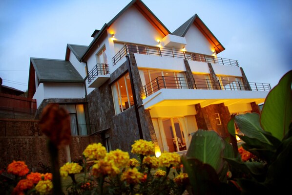 A multi-story modern house with balconies and large windows.