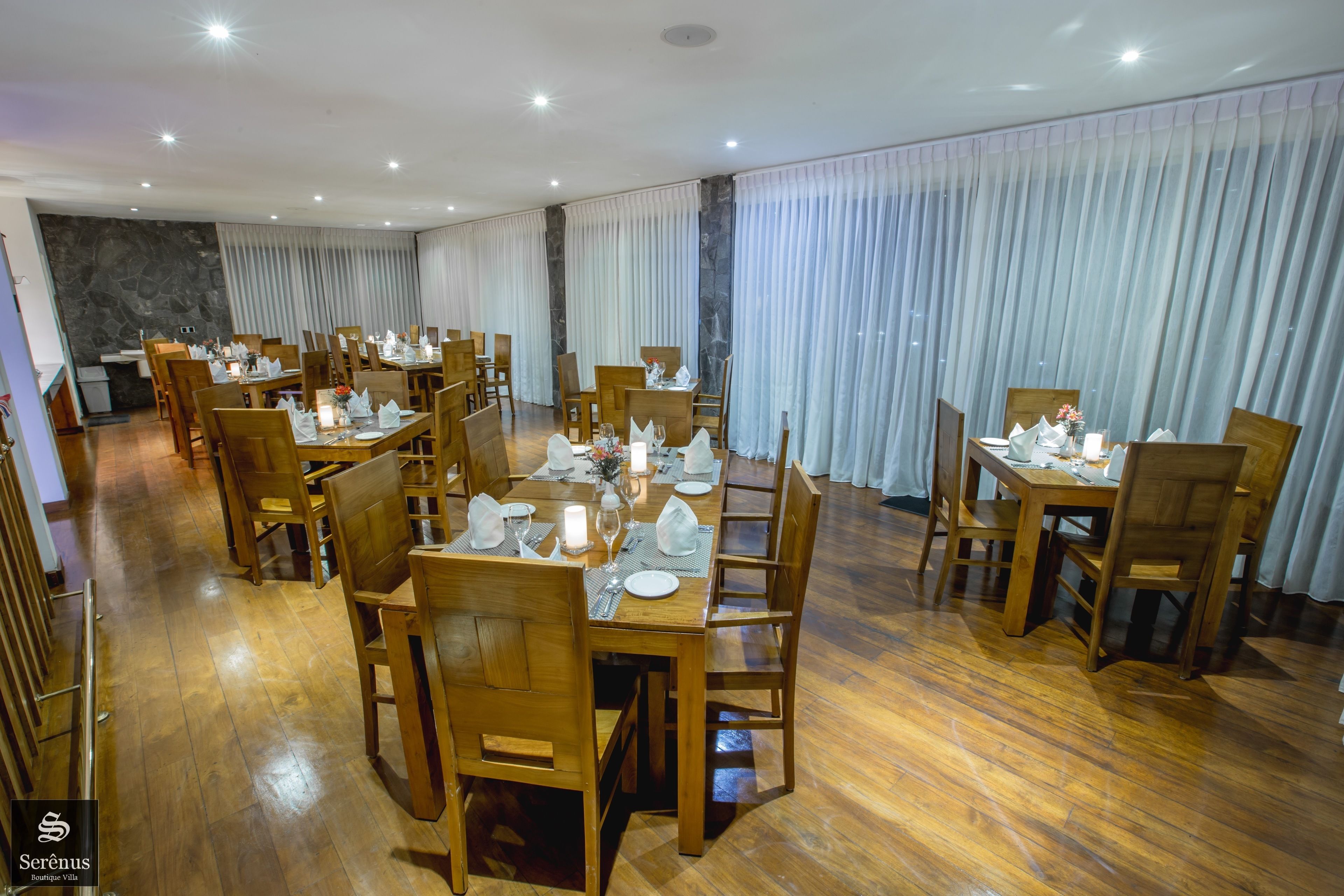 A dining area with wooden tables and chairs, arranged for service.