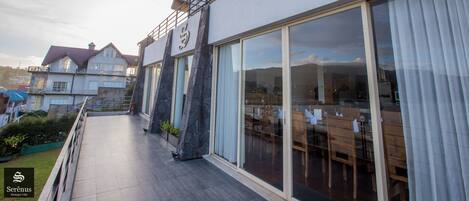 Una casa moderna con balcón, ventanas amplias y comedor.
