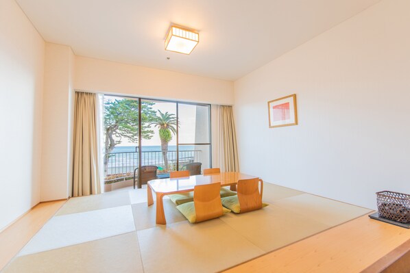 A room with a large window, a wooden table, and a chair.