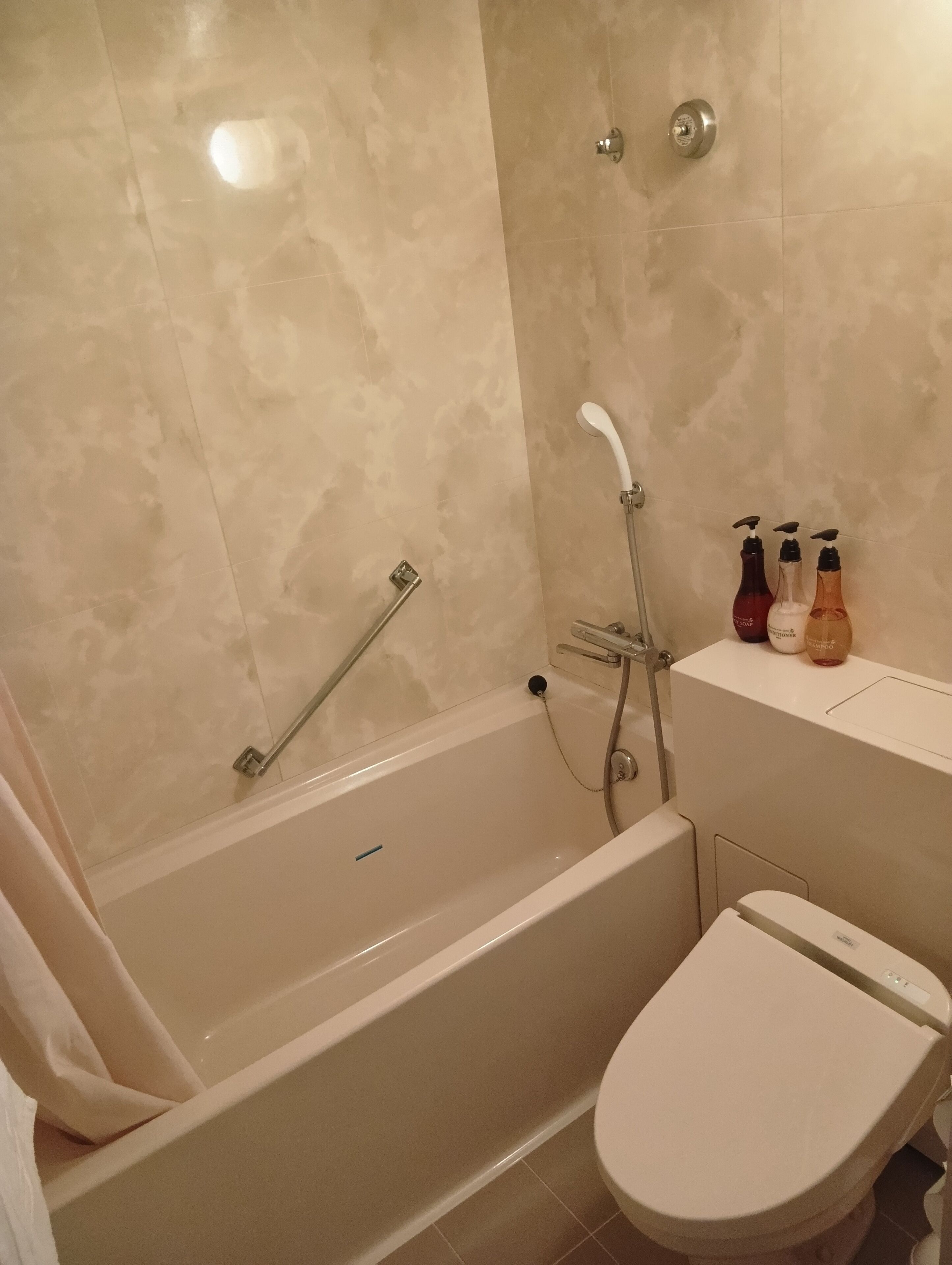 Un baño con bañera, inodoro y zona de ducha.