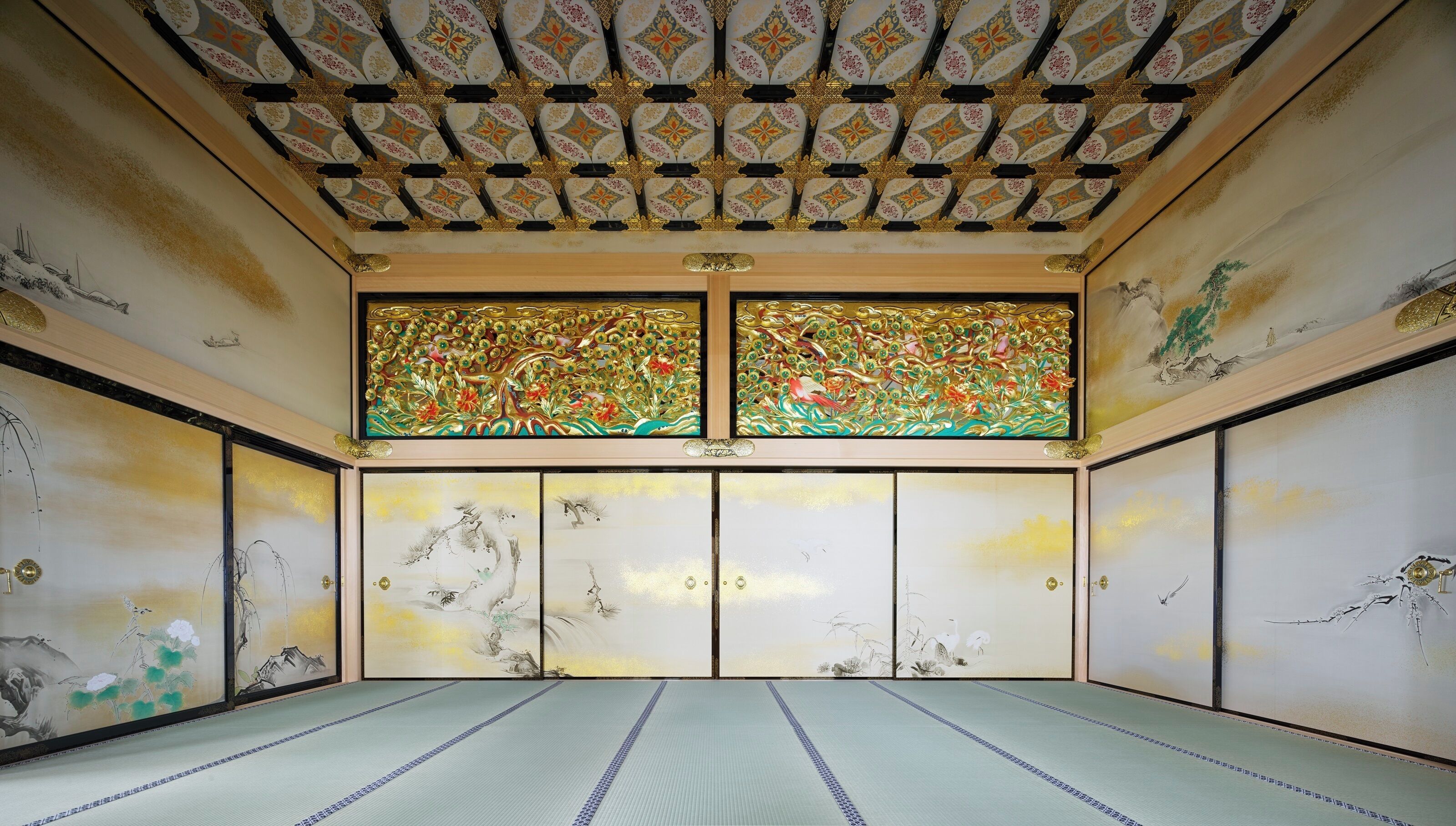 A traditional Japanese room with tatami flooring, sliding doors, and a ceiling with intricate patterns.
