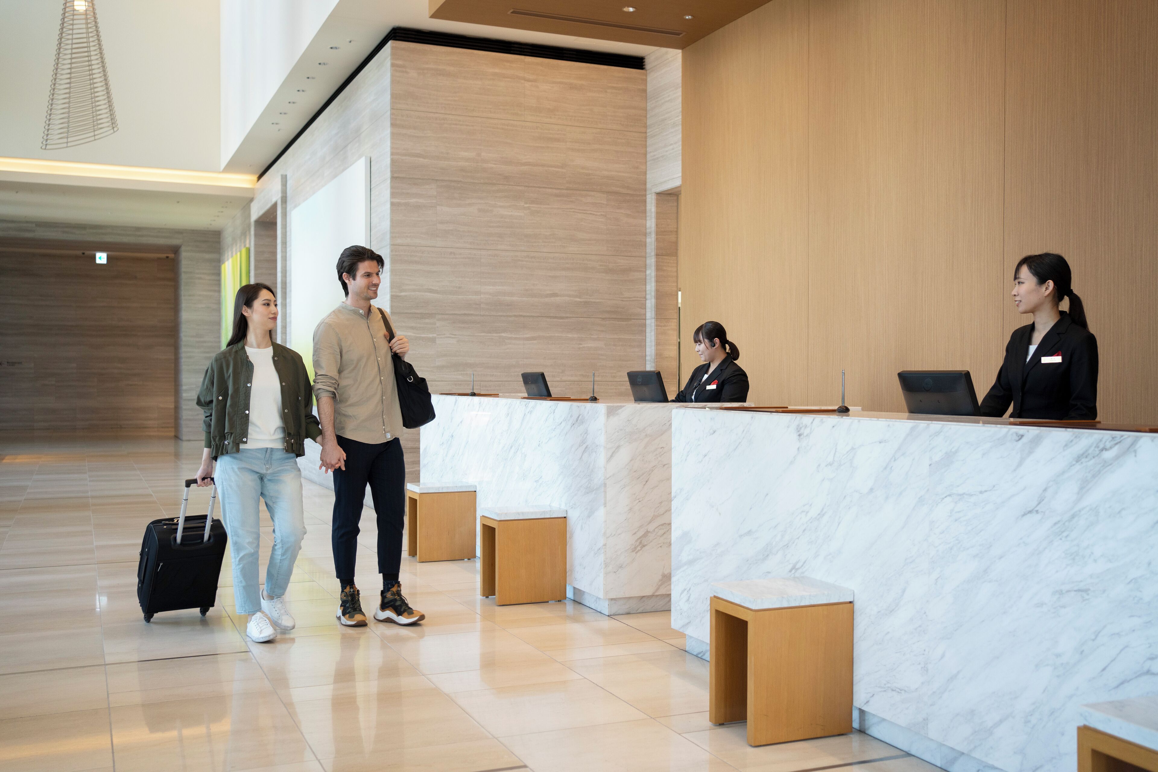 A modern reception area with marble counters, wooden accents, and a clean, minimalist design.