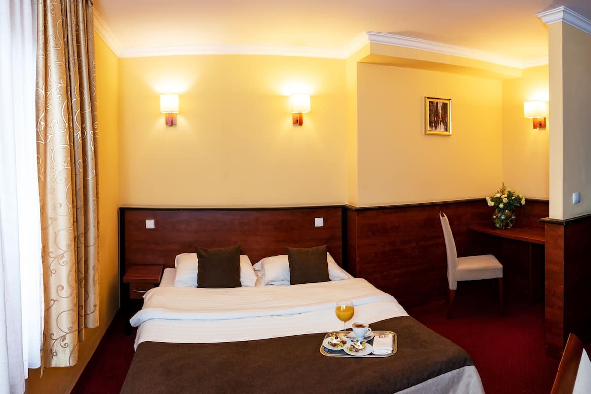 Une chambre d’hôtel comprenant un lit, des tables de chevet, un bureau et une chaise.