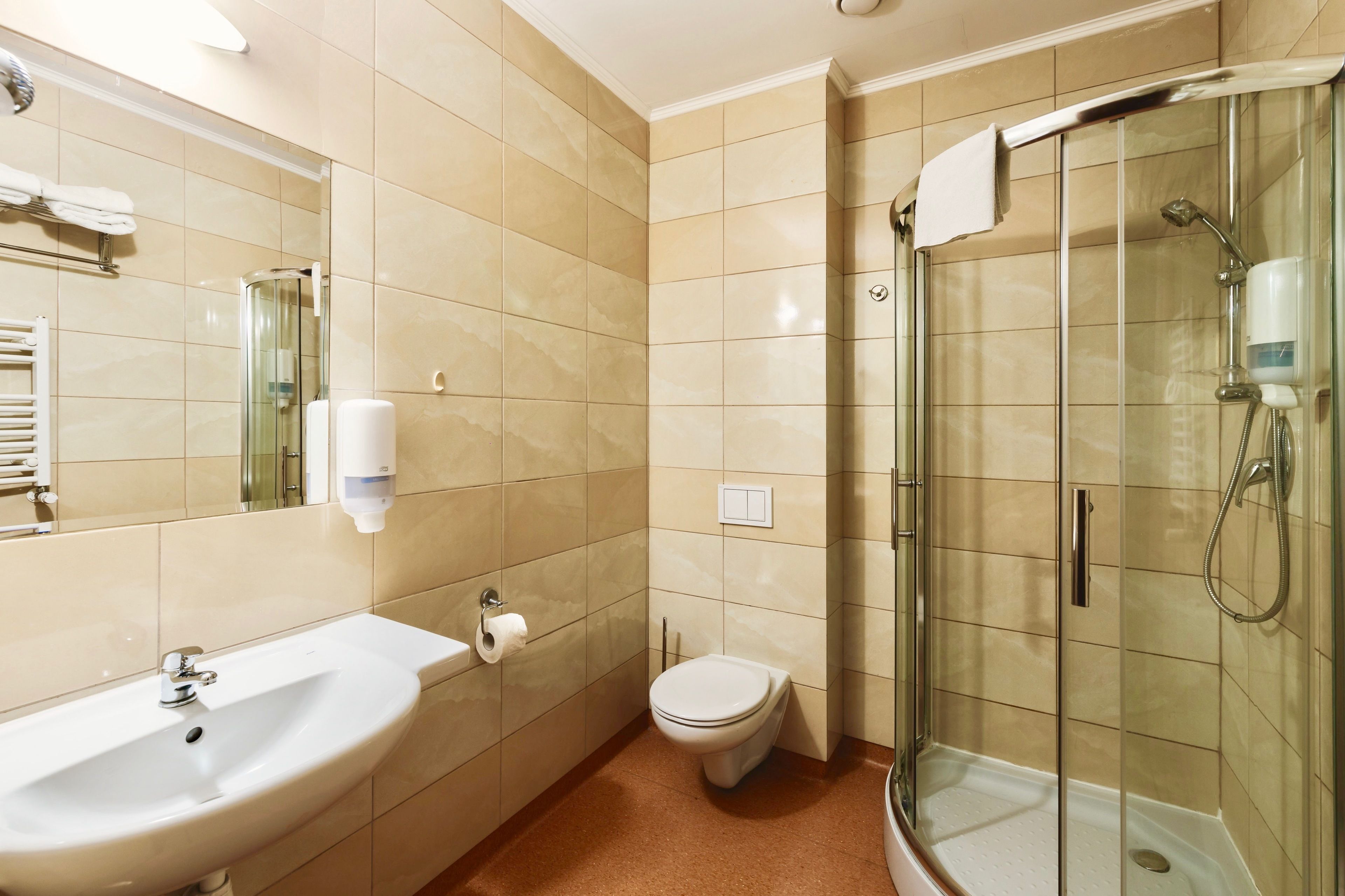 A bathroom with a sink, toilet, and glass-enclosed shower.