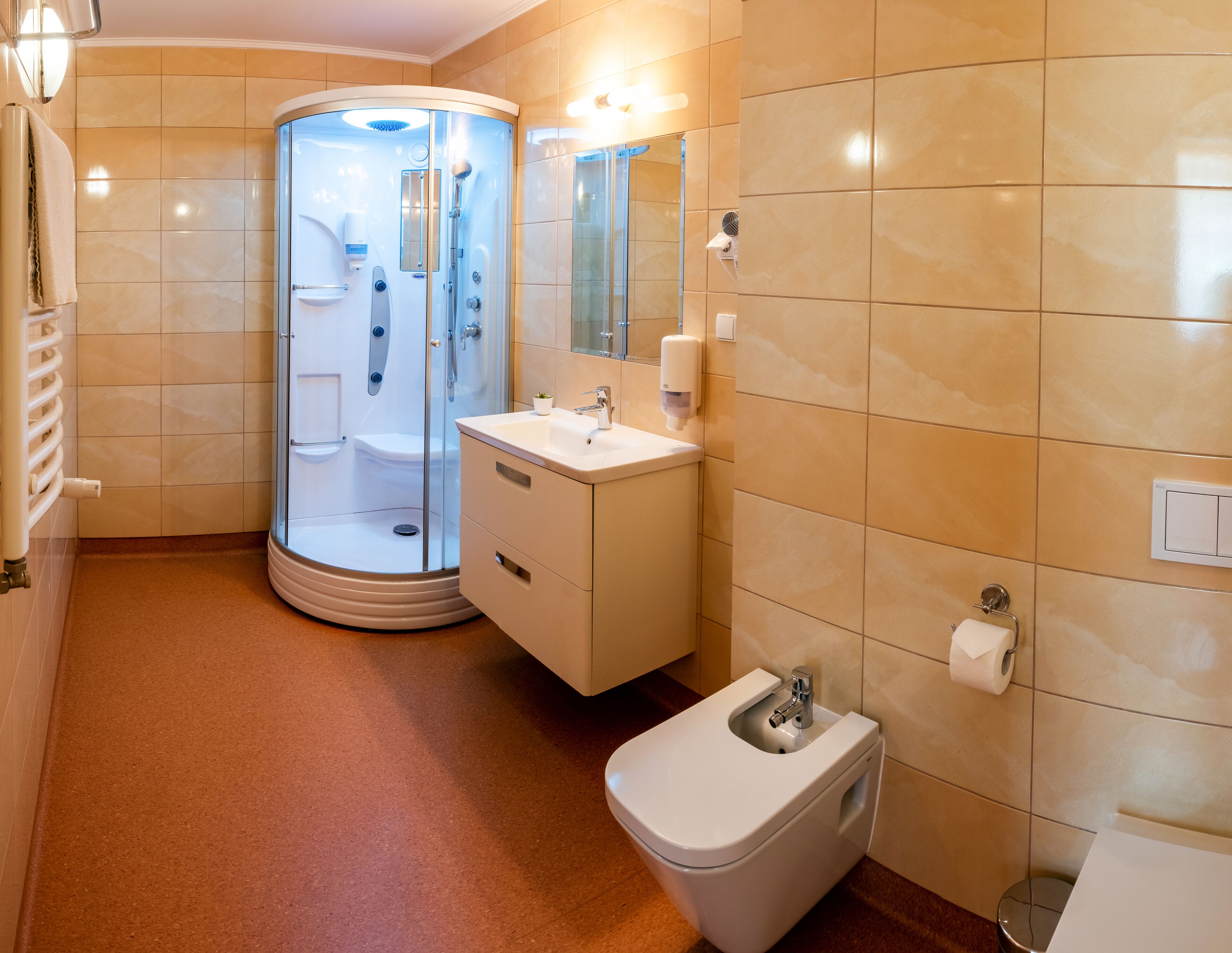 A modern bathroom with a glass-enclosed shower, a white sink, and a toilet.