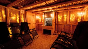 Acogedor interior de cabaña de troncos con paredes de madera, chimenea y zonas de estar.
