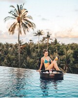 Una piscina al aire libre, sillones reclinables de piscina