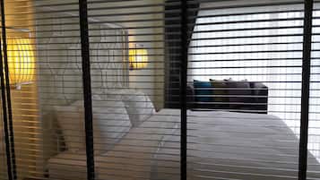 Ein Hotelzimmer mit einem Bett, einem Nachttisch und einem Fenster mit Jalousien.