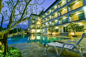 A hotel with a swimming pool, outdoor seating, and a multi-story building with balconies. - Southgate Residence Hotel (Chumphon)