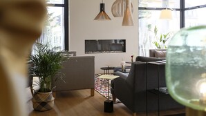 A modern living room with a sofa, a coffee table, and a potted plant. - James Boutique Hôtel (Colmar)