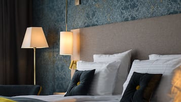 A hotel room with a bed, two bedside lamps, and a textured wall.