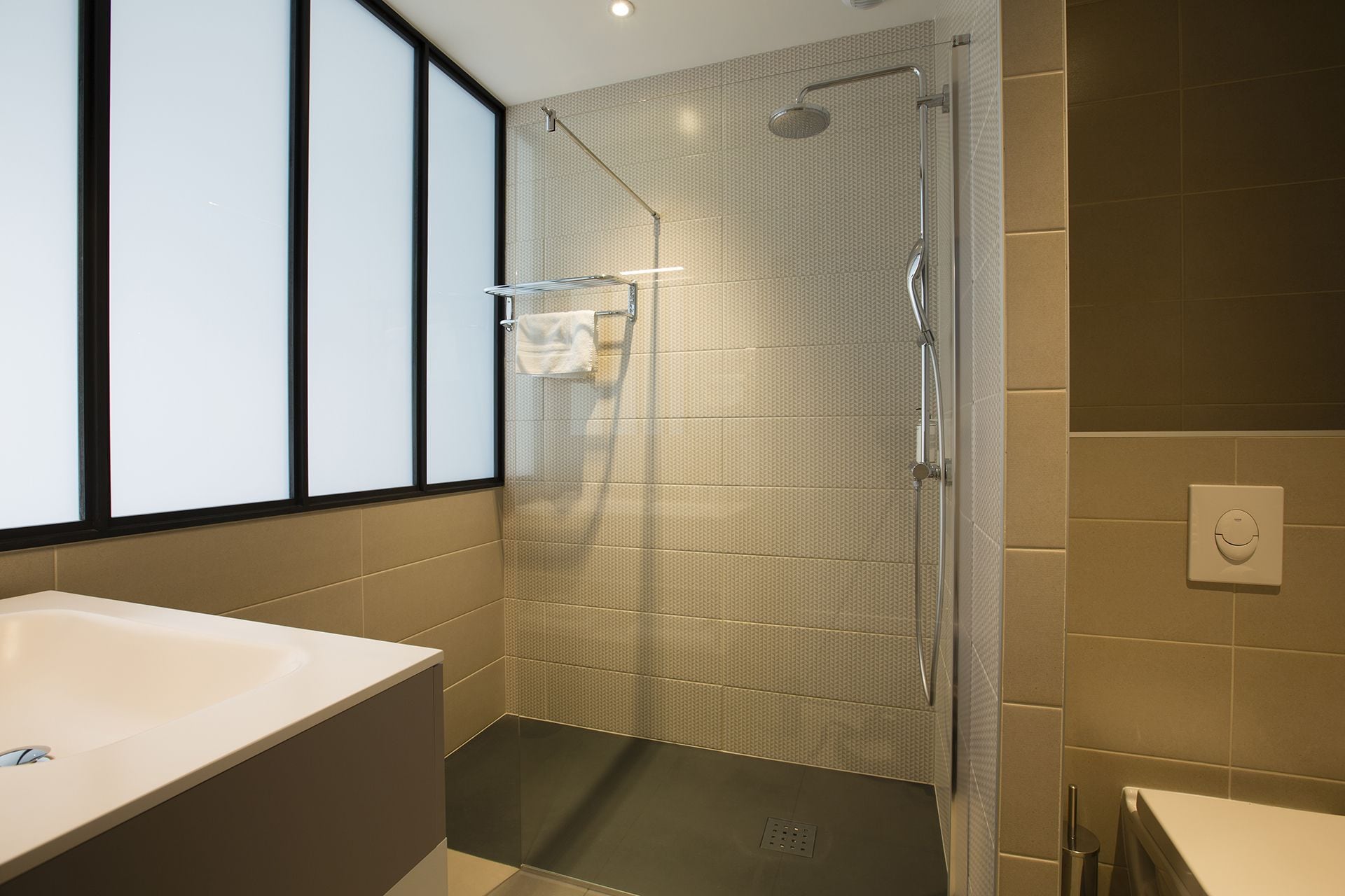 Une salle de bain moderne avec une grande baignoire, une douche à l’italienne et des toilettes.