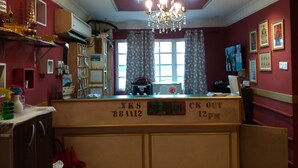 A reception area with a chandelier, a reception desk, and a window with curtains. - City Inn Hotel (Kuala Lumpur)