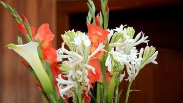 A bouquet of flowers with red and white blooms, possibly including lilies and tulips, in a vase.
