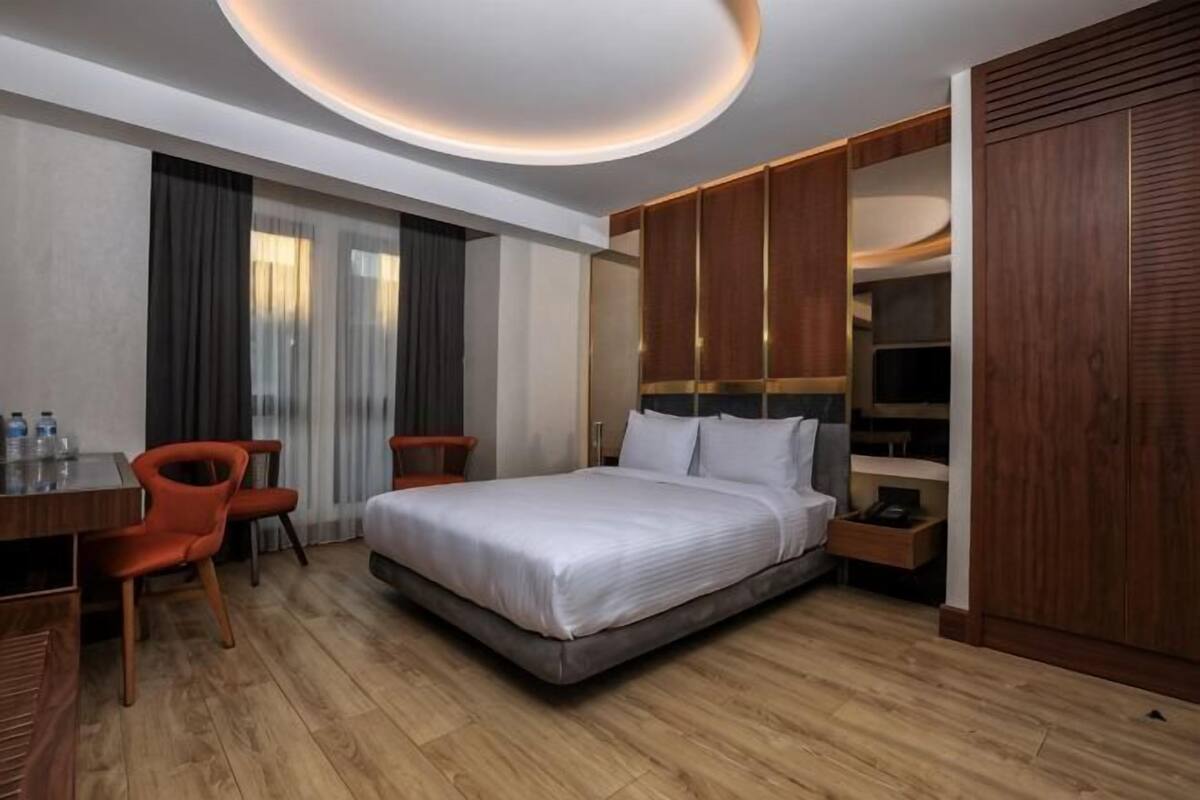 Une chambre d’hôtel équipée d’un lit, d’un bureau, de chaises et d’une armoire.