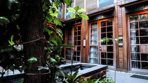 A building with wooden doors and windows, a tree, and a small water feature. - Henna Hotel Istanbul (Istanbul)