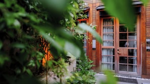 A wooden building with a glass door and windows, surrounded by greenery. - Henna Hotel Istanbul (Istanbul)