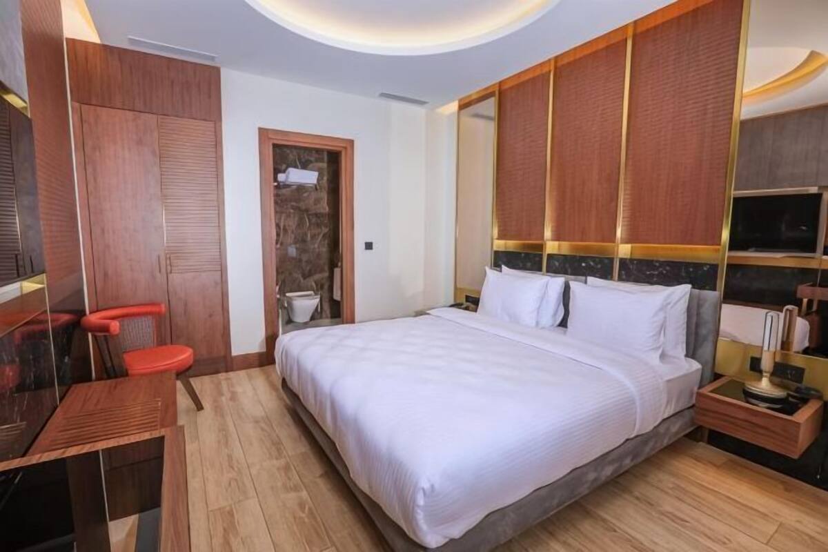 Une chambre à coucher avec un lit, une armoire en bois et un bureau.