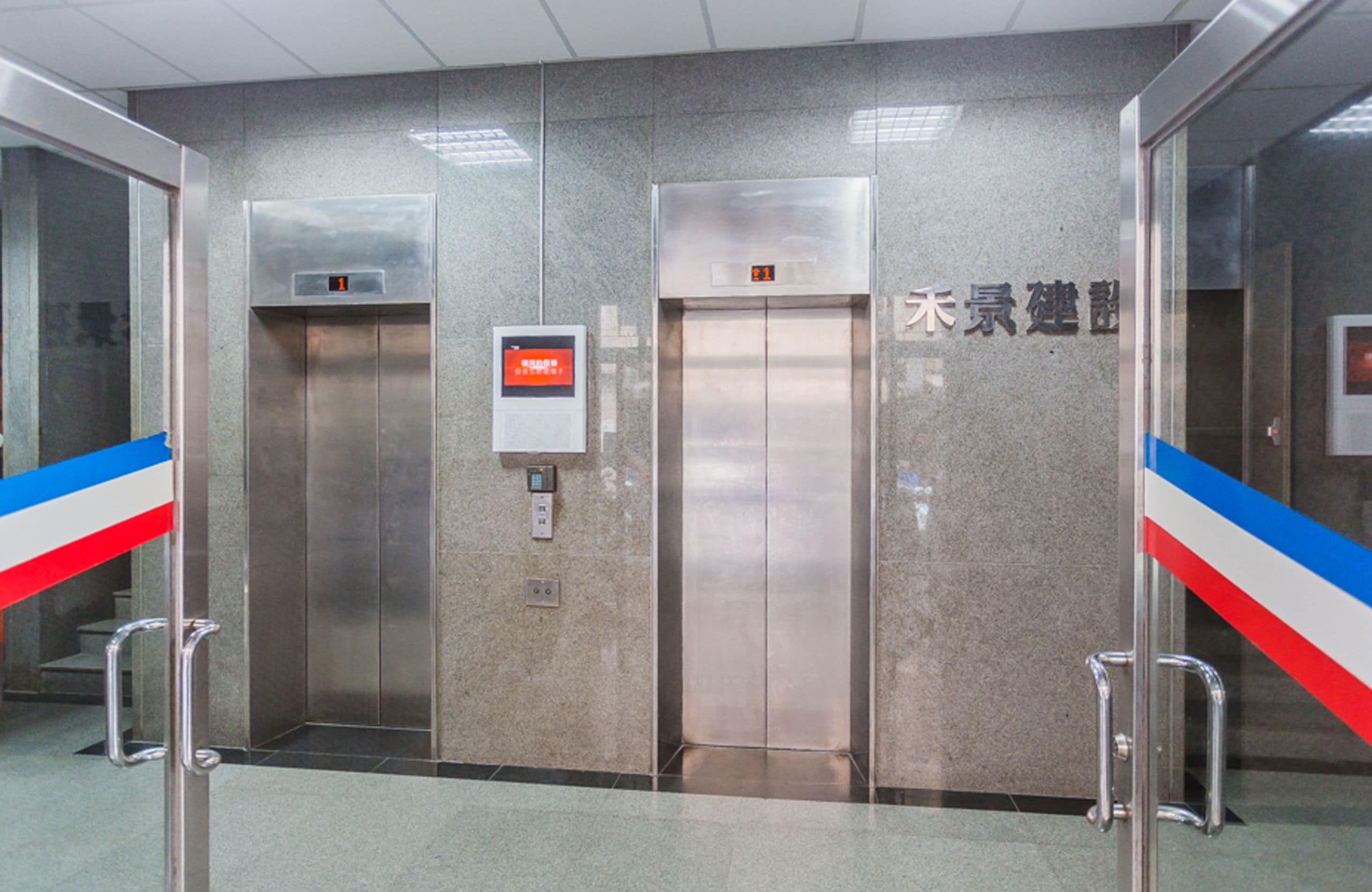 An elevator with a digital display, a control panel, and a sign with Chinese characters.