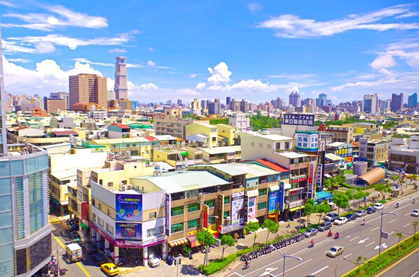 Un paysage urbain comprenant divers bâtiments, notamment une tour imposante et un mélange de structures commerciales et résidentielles.