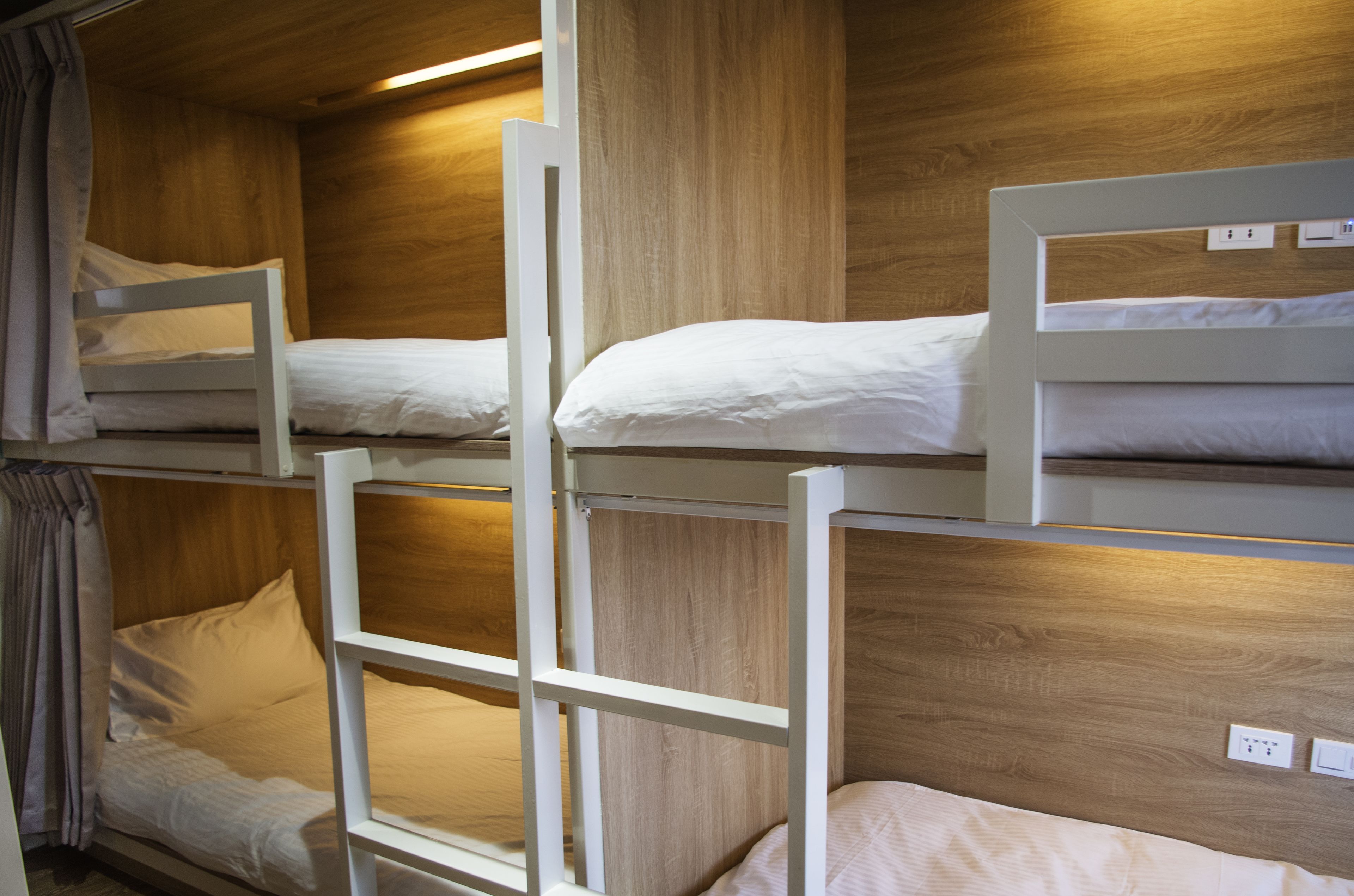 A bunk bed room with wooden walls and white bedding.