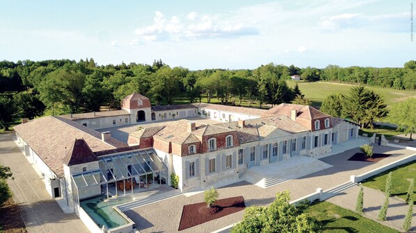 A large, historic building with multiple wings and a central courtyard, surrounded by lush greenery. - Château Prieuré Marquet - Chambres d'Hôtes D'exception (Saint-Martin-du-Bois)