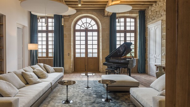 A spacious living room with a grand piano, a sofa, and a coffee table. - Château Prieuré Marquet - Chambres d'Hôtes D'exception (Saint-Martin-du-Bois)