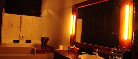 A bathroom with a bathtub, a sink, and a large mirror.