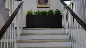 A staircase with white railings and a black baseboard. - YMCA Tourist Hostel (New Delhi)