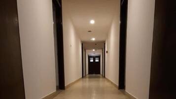 A long, narrow hallway with a tiled floor and white walls.