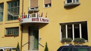 A yellow building with a sign reading "HOTEL S. Marco" and multiple flags. - Hotel San Marco BB (Darfo Boario Terme)
