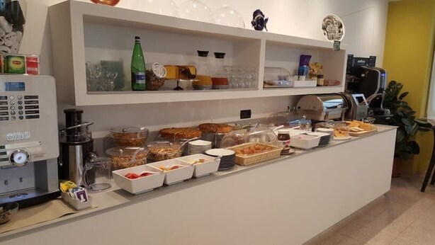 A buffet setup with various food items and beverages. - Hotel San Marco BB (Darfo Boario Terme)