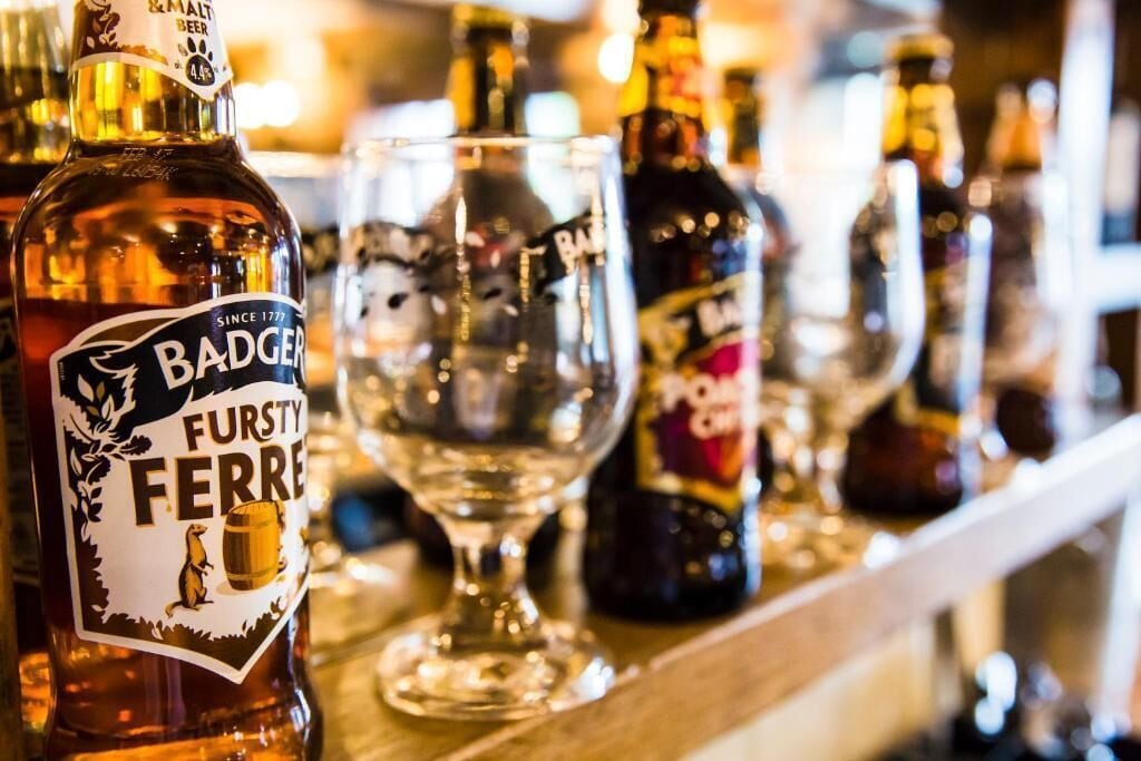 A bar with bottles and glasses, including a bottle labeled 'BADGER FURSTY FERRE.'
