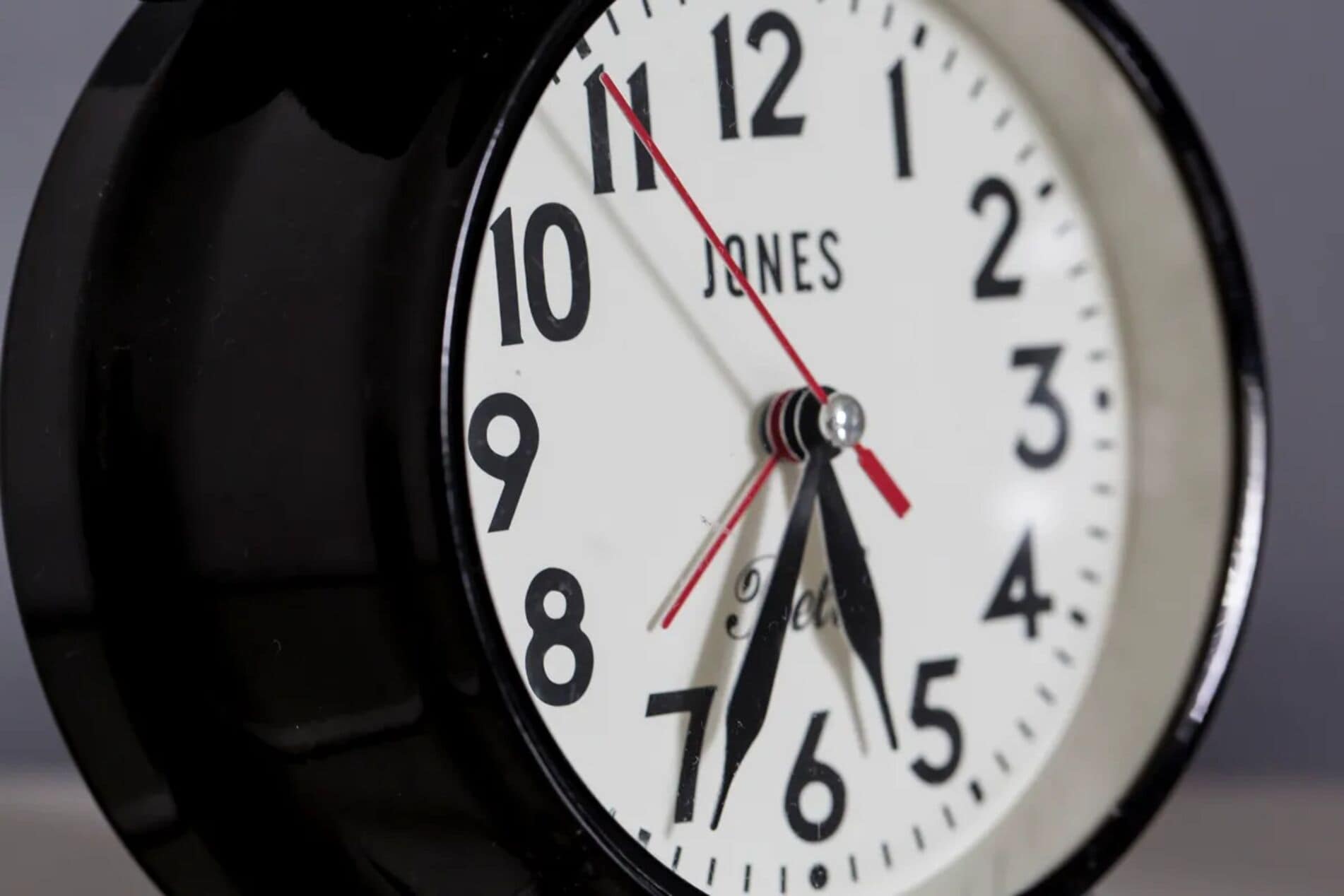A close-up of a clock with the brand 'JONES' on its face.