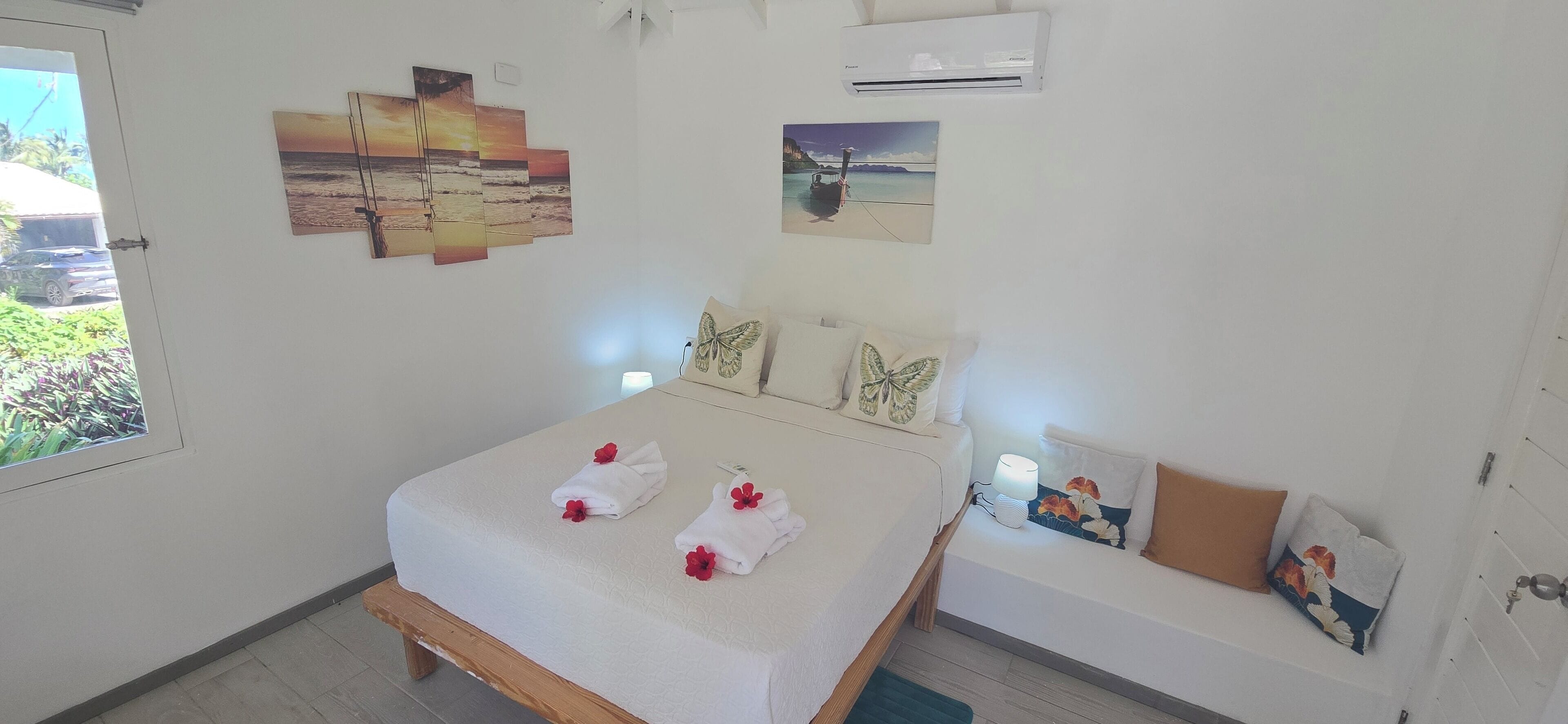 A neatly arranged bedroom with a bed, pillows, and wall art.