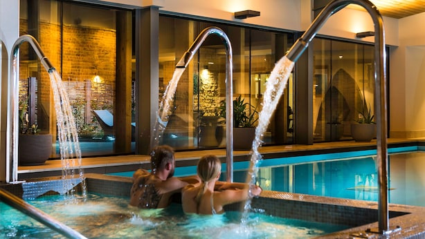 Zona de piscina con varias fuentes de agua y vistas al interior.