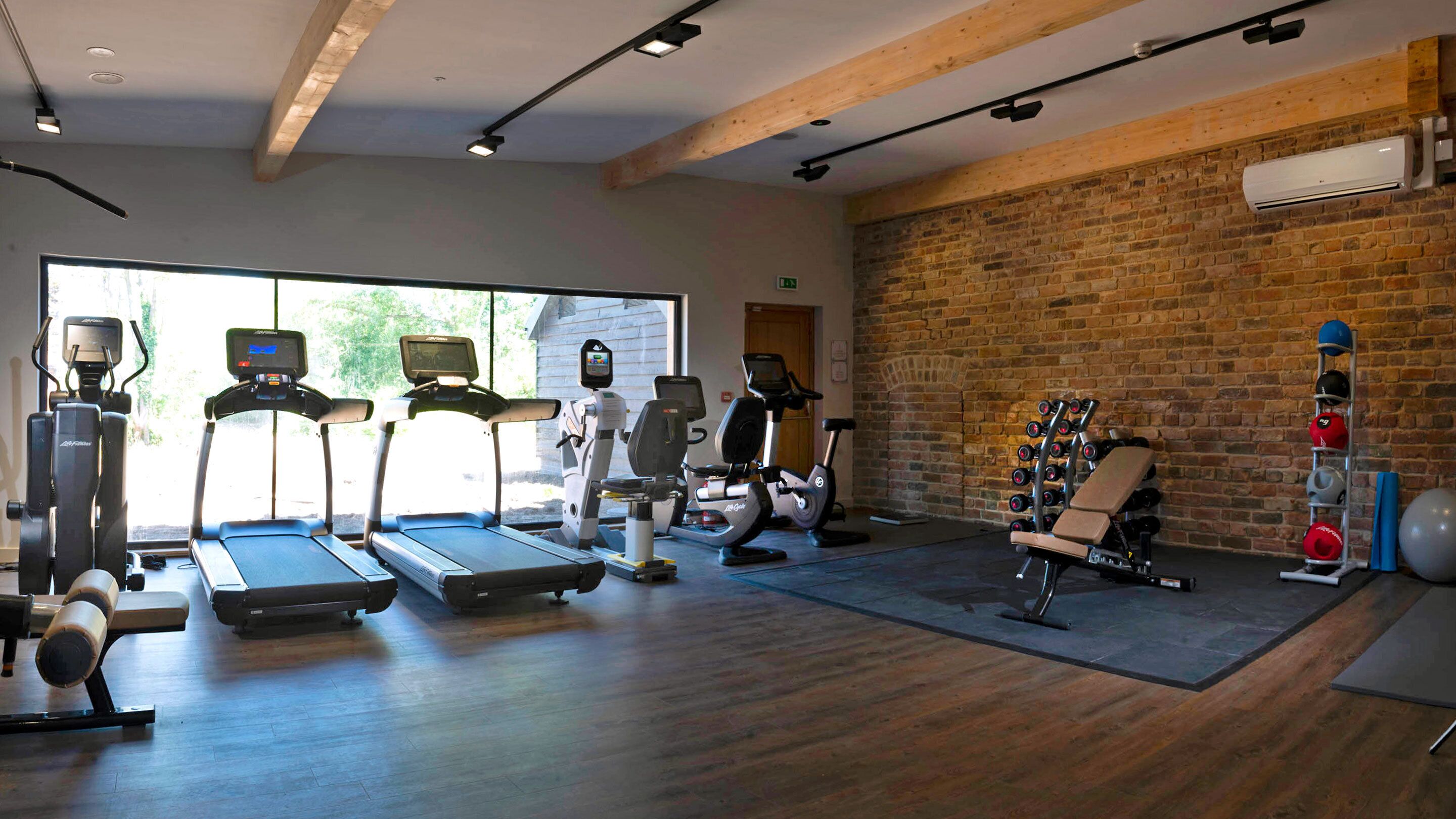 A gym with treadmills, elliptical machines, and weightlifting equipment.